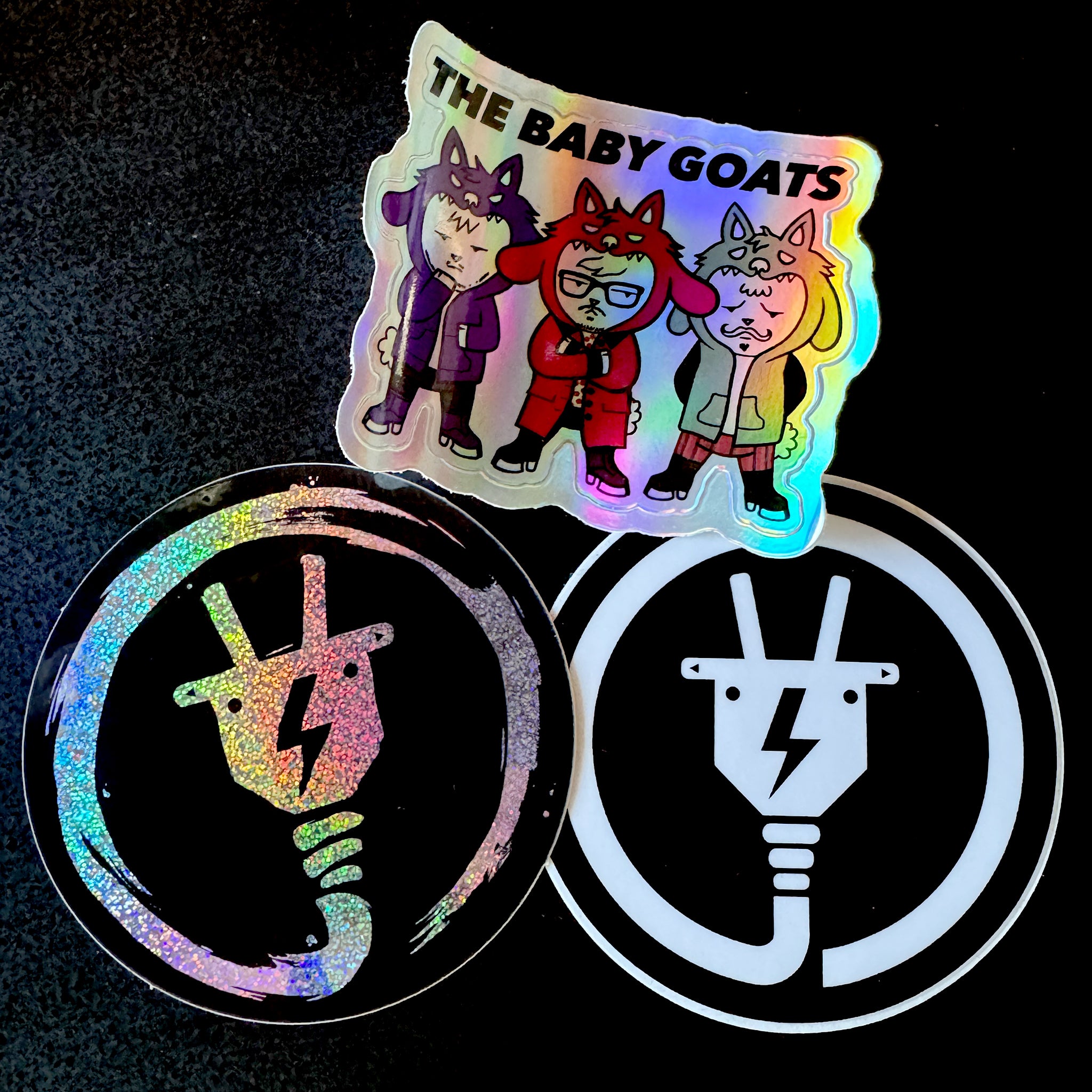 Holographic stickers with cartoon characters and symbols on a dark background