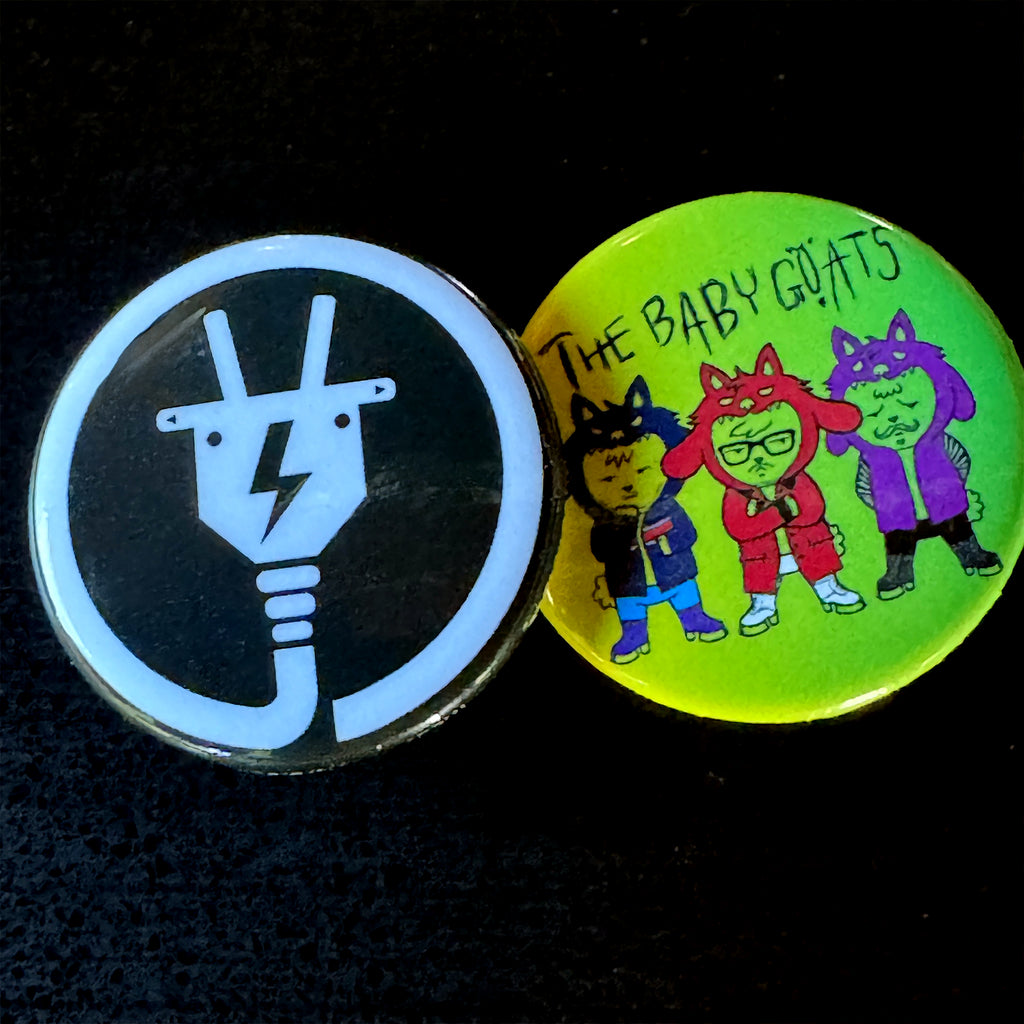 Two buttons from The Baby Goats with different designs on a black background